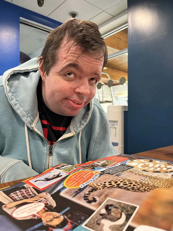 Client pulling a playful face over a magazine